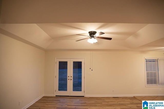 spare room with french doors, a tray ceiling, ceiling fan, and hardwood / wood-style floors