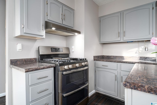 kitchen with stainless steel range with gas cooktop, dark wood-type flooring, and gray cabinetry