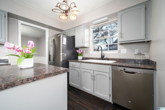 kitchen featuring appliances with stainless steel finishes, sink, a notable chandelier, white cabinets, and dark hardwood / wood-style floors