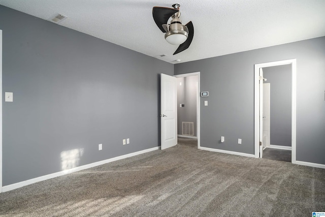 unfurnished bedroom with ceiling fan, a textured ceiling, and dark colored carpet