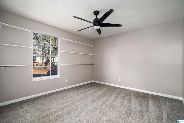 carpeted spare room featuring ceiling fan and a textured ceiling