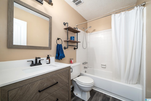 full bathroom with shower / bath combo, vanity, a textured ceiling, hardwood / wood-style floors, and toilet