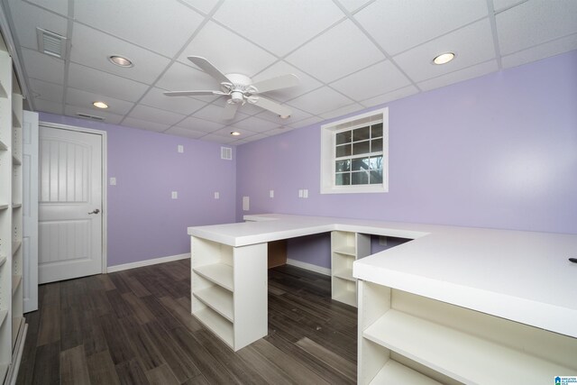 unfurnished office with ceiling fan, dark hardwood / wood-style flooring, and a drop ceiling