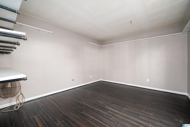 spare room with dark hardwood / wood-style floors and a textured ceiling