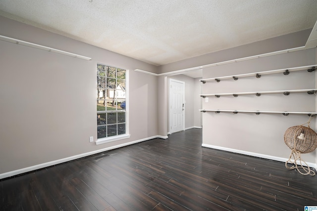 empty room with dark hardwood / wood-style flooring and a textured ceiling