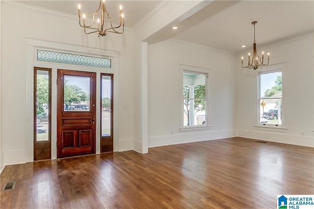 foyer entrance with crown molding, a chandelier, and dark hardwood / wood-style floors