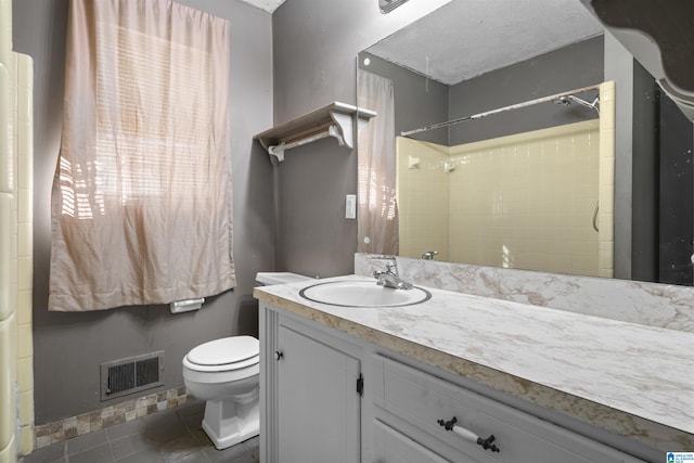 bathroom featuring tile patterned floors, vanity, toilet, and walk in shower