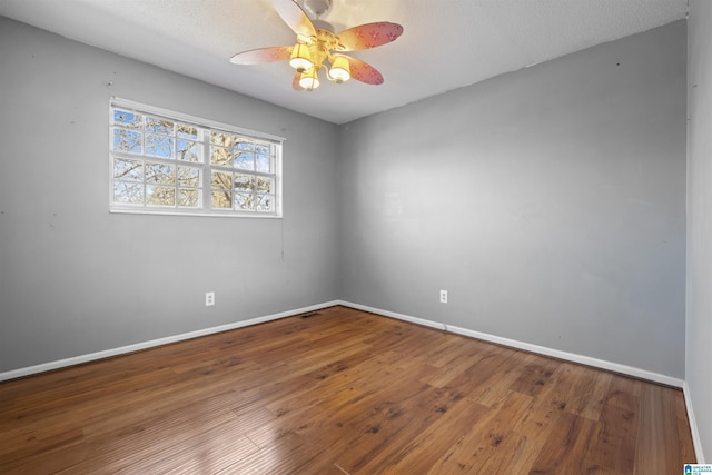 spare room with hardwood / wood-style flooring, ceiling fan, and a textured ceiling