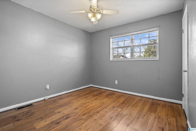 empty room with ceiling fan and hardwood / wood-style floors