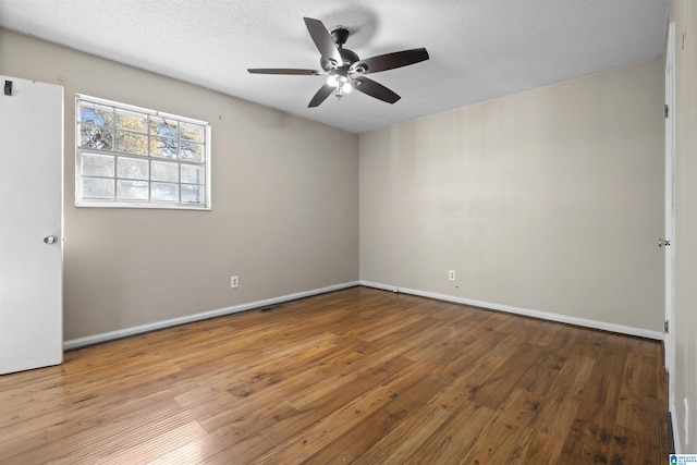 empty room with ceiling fan, hardwood / wood-style floors, and a textured ceiling