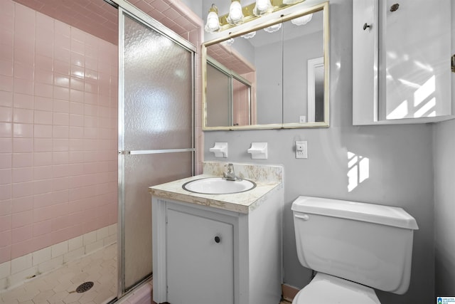 bathroom featuring vanity, toilet, and a shower with shower door