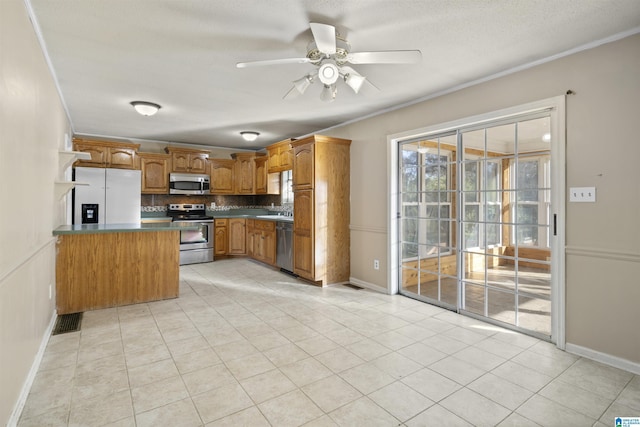 kitchen with appliances with stainless steel finishes, backsplash, ceiling fan, sink, and light tile patterned floors