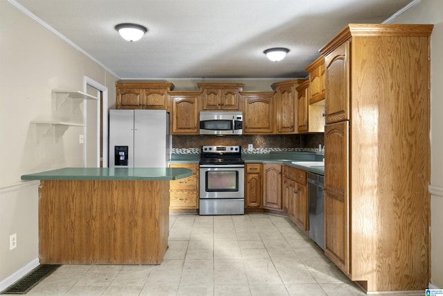 kitchen featuring backsplash, ornamental molding, stainless steel appliances, and a textured ceiling