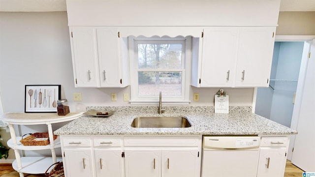 kitchen featuring white dishwasher, white cabinetry, light hardwood / wood-style floors, and sink