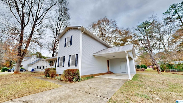 view of side of home featuring a yard and a carport