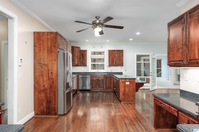 kitchen with dark wood-type flooring, sink, decorative backsplash, ornamental molding, and stainless steel appliances