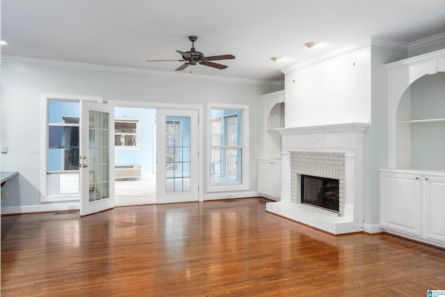 unfurnished living room featuring a brick fireplace, ceiling fan, french doors, and hardwood / wood-style flooring