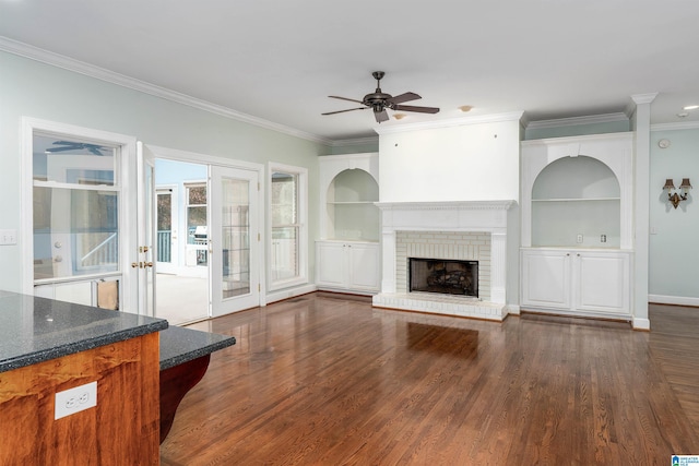 unfurnished living room with a fireplace, dark hardwood / wood-style flooring, built in features, and ornamental molding