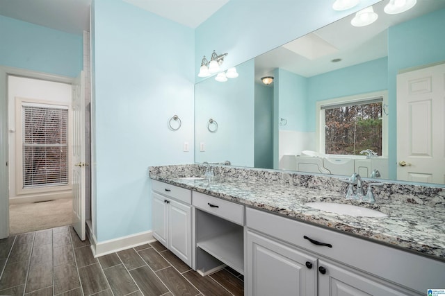 bathroom with a tub and vanity