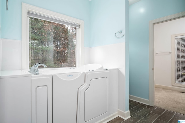 bathroom featuring a tub to relax in and wood-type flooring