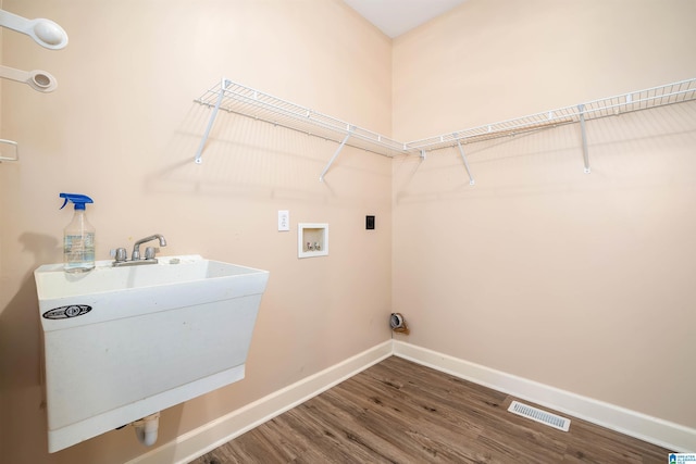 laundry area featuring hardwood / wood-style floors, electric dryer hookup, sink, and washer hookup