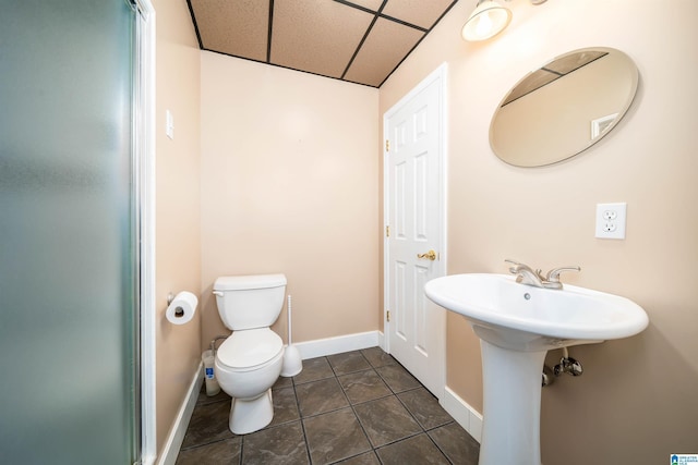 bathroom featuring a paneled ceiling, sink, tile patterned flooring, and toilet