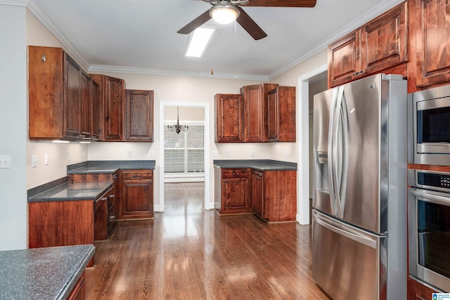 kitchen featuring dark hardwood / wood-style flooring, ornamental molding, ceiling fan with notable chandelier, and appliances with stainless steel finishes