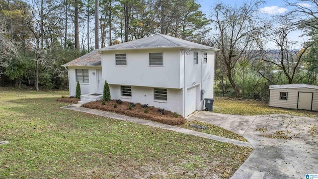 view of front of home with a storage unit, a front yard, and a garage