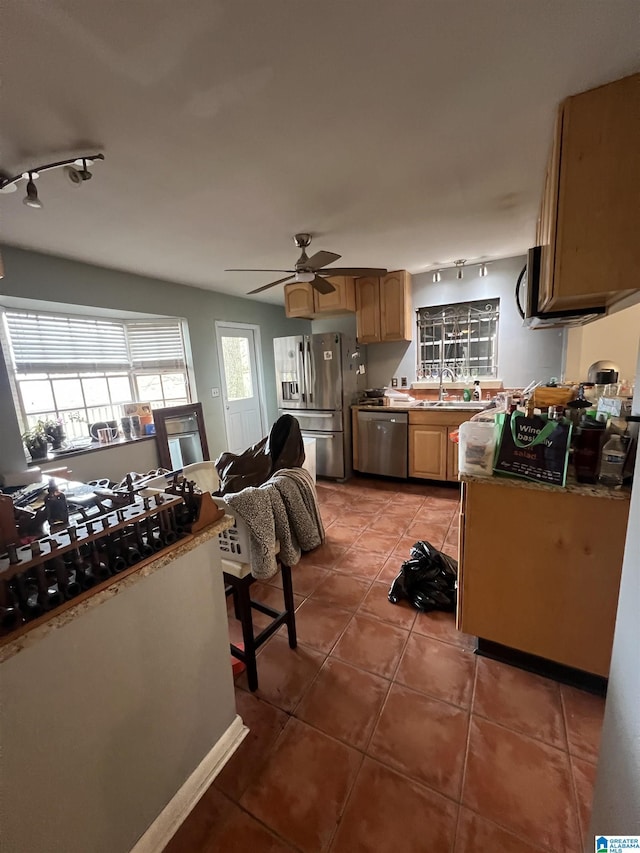 kitchen with rail lighting, stainless steel appliances, dark tile patterned flooring, and sink