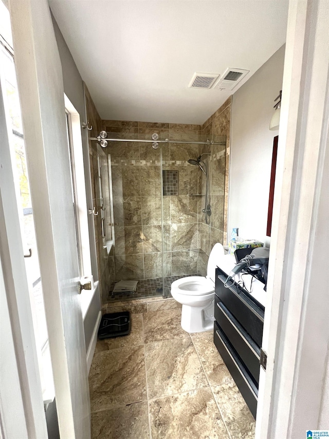 bathroom with a shower with door, vanity, and toilet