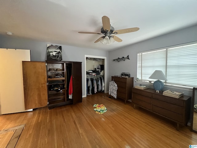 bedroom with ceiling fan, wood-type flooring, and a closet