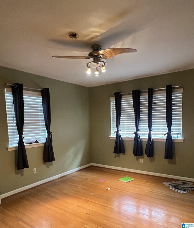 spare room with ceiling fan, plenty of natural light, and light wood-type flooring