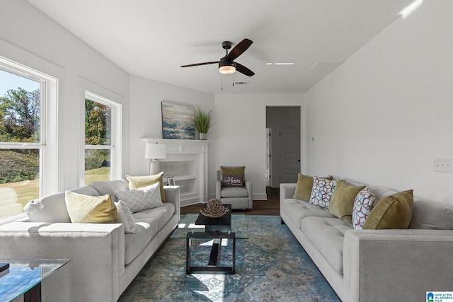 living room with ceiling fan and dark wood-type flooring