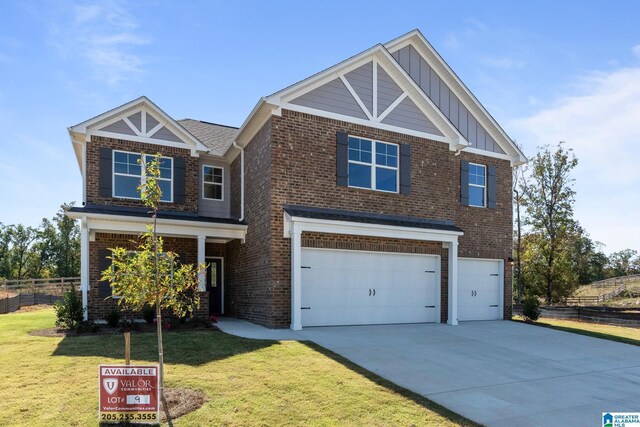 craftsman house with a front yard and a garage