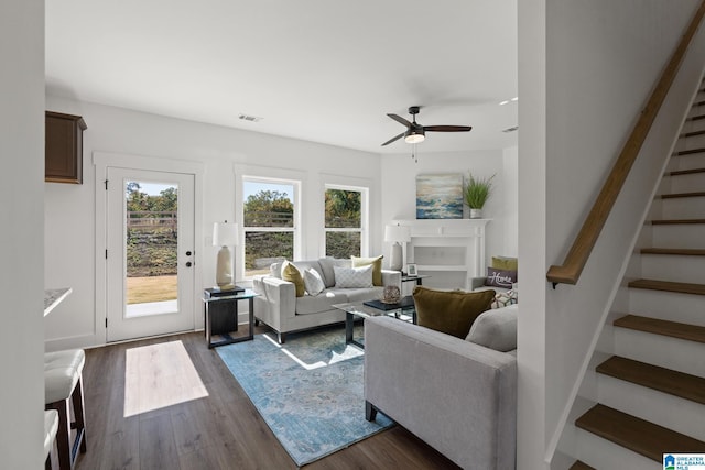 living room with ceiling fan and dark wood-type flooring