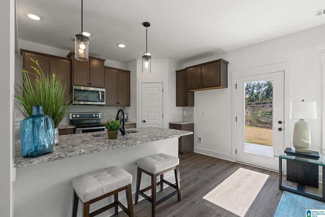 kitchen with dark brown cabinets, sink, stainless steel appliances, and dark hardwood / wood-style floors