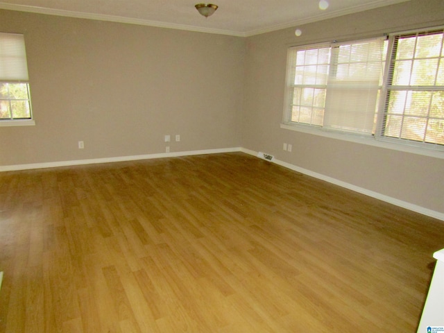 spare room featuring hardwood / wood-style floors and crown molding