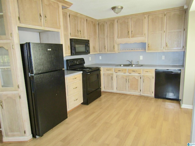 kitchen with light brown cabinetry, sink, light hardwood / wood-style flooring, and black appliances