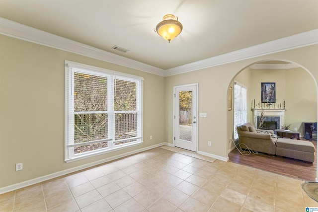 tiled foyer with crown molding and plenty of natural light