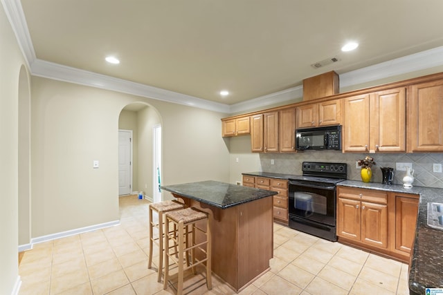 kitchen featuring a kitchen breakfast bar, backsplash, a kitchen island, black appliances, and ornamental molding