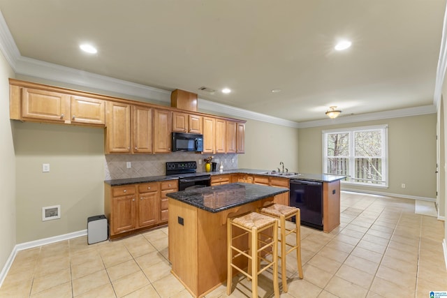 kitchen featuring kitchen peninsula, backsplash, sink, black appliances, and a center island