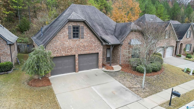 view of front of property with a shingled roof, a front yard, brick siding, and driveway