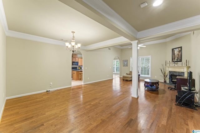 living room featuring crown molding, wood-type flooring, and a notable chandelier