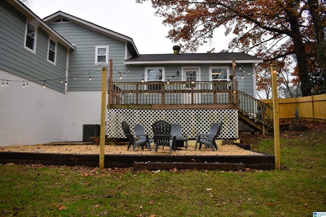 rear view of house with a lawn, cooling unit, and a deck