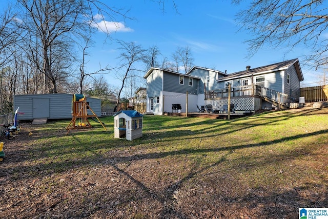 view of yard featuring a playground, a deck, and a storage shed