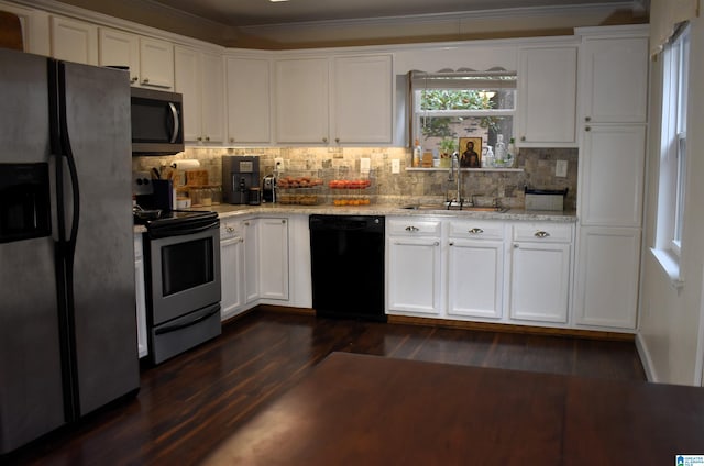 kitchen with light stone countertops, dark hardwood / wood-style flooring, stainless steel appliances, sink, and white cabinets