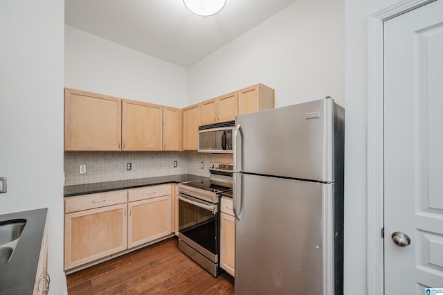 kitchen featuring light brown cabinets, backsplash, stainless steel appliances, and dark wood-type flooring