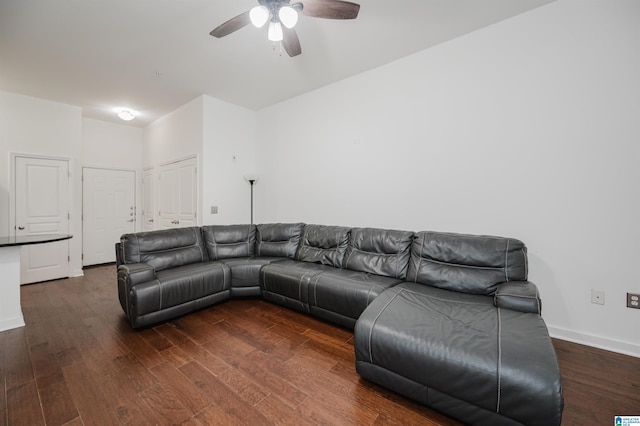 living room with ceiling fan and dark wood-type flooring