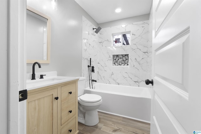 full bathroom featuring vanity, hardwood / wood-style flooring, toilet, and tiled shower / bath