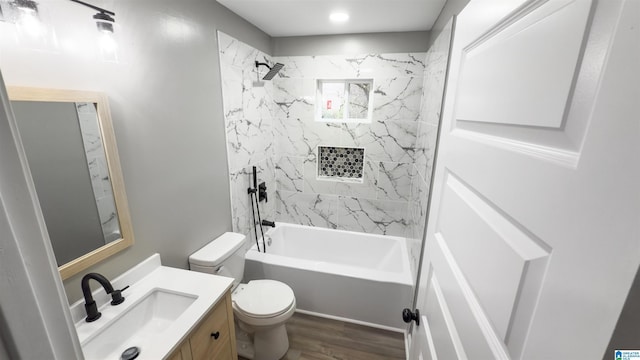 full bathroom with vanity, toilet, wood-type flooring, and tiled shower / bath